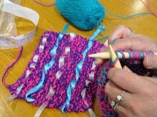 Knitting combined with threaded ribbons to create a textured patch for Aladdin&#039;s Magic Carpet.